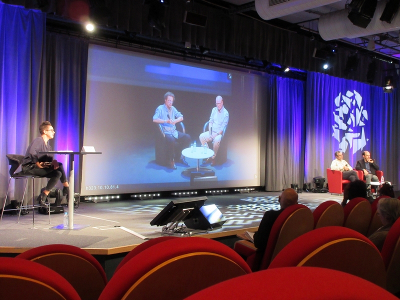 De gauche à droite : l'animatrice du débat, l'écran avec les deux scientifiques à Lyon, les deux scientifiques à Paris