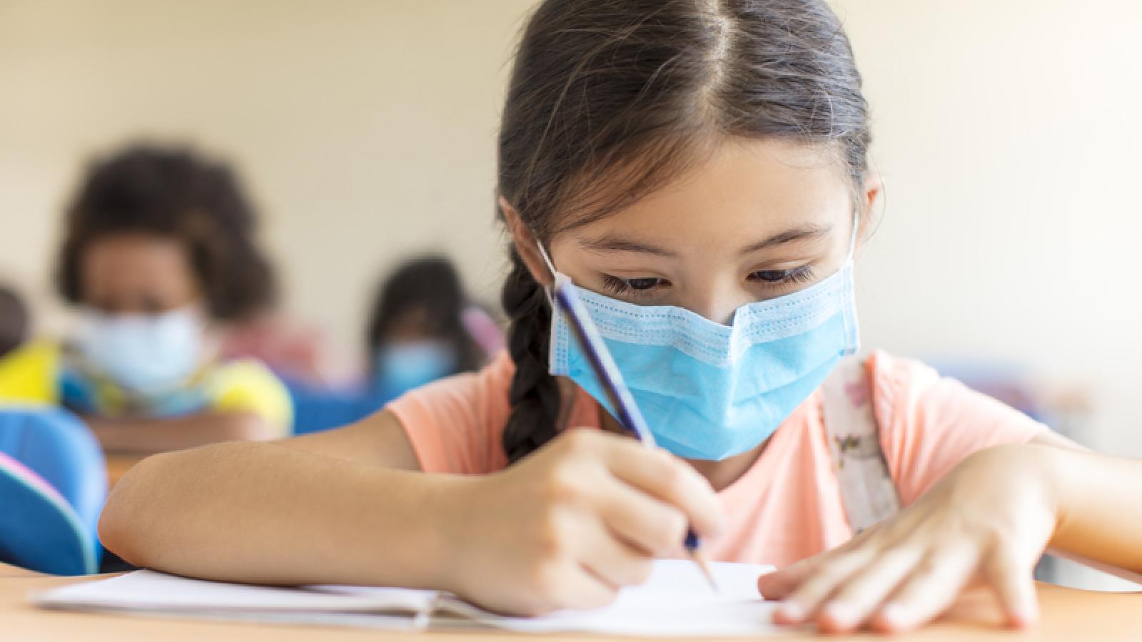 Fillette en classe avec masque