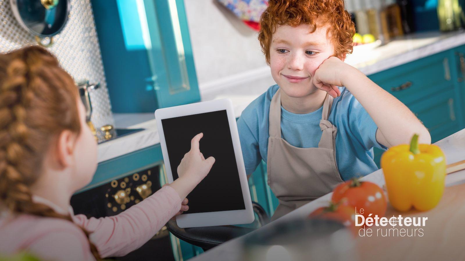 Des enfants jouent avec une tablette électronique
