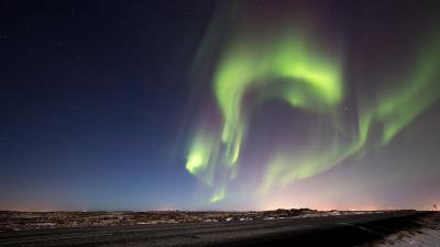 Aurore boréale verte au-dessus d'une route