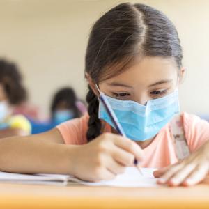 Fillette en classe avec masque