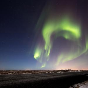 Aurore boréale verte au-dessus d'une route