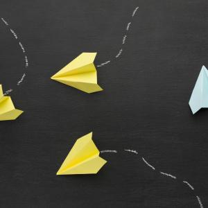 Représentation de vols d'avion avec des avions en papier sur fond noir
